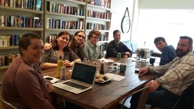 Photo of the MENding program in action, seven people sit around a table smiling at the camera.